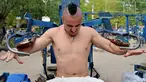 Valentyn (25) mengangkat beban saat berlatih fitnes di sebuah gym outdoor di Ibu Kota Ukraina, Kiev, 18 Agustus 2017. Alat olahraga di gym tersebut dibuat seorang teknisi bernama Yuri Kook pada dekade 1970-an. (GENYA SAVILOV/AFP)