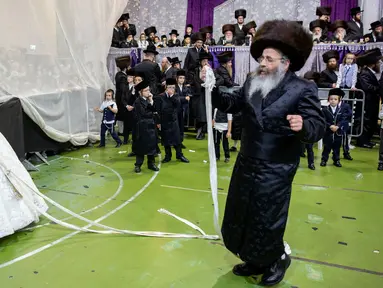 Pengantin Yahudi ultra-ortodoks Hannah Halbershtam memasuki bagian pria saat melangsungkan upacara pernikahan di kota ultra-ortodoks Bnei Brak, Israel, Selasa (20/8/2019. Dalam acara ini keluarga dan para rabi terhormat diundang untuk menari di depan pengantin wanita. (AP Photo/Oded Balilty)