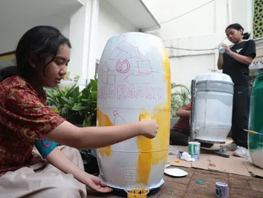 Sejumlah siswa komunitas perkusi Labsky Kebayoran "Dungtakravara" mengecat alat musik berbahan daur ulang di SMA Labschool Kebayoran, Jakarta Selatan, Kamis (23/7/2026). Drum plastik bekas, galon air mineral, diolah menjadi alat musik dan dekorasi panggung untuk drama musikal Skylite serta pentas seni Skyavenue 2026. (KLY/ Budy Santoso)