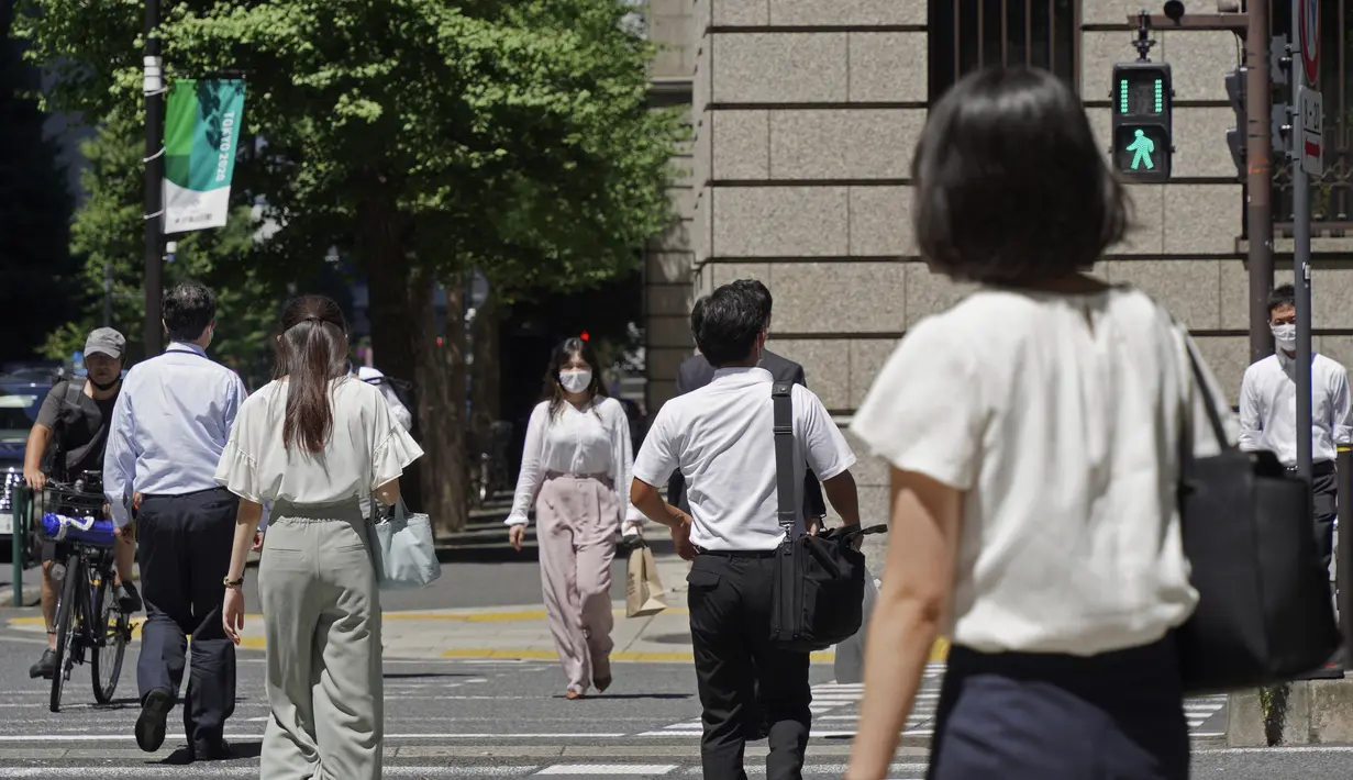 Orang-orang yang memakai masker melintasi persimpangan di Tokyo Kamis (5/8/2021). Meningkatnya kasus virus corona di sejumlah wilayah di Jepang, termasuk Tokyo, membuat pemerintah memperluas status darurat terbatas Covid-19 ke delapan prefektur. (AP Photo/Kantaro Komiya)