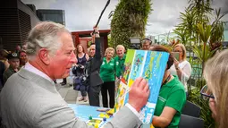 Pangeran Charles memberi sentuhan akhir pada lukisan anak-anak di Brisbane, Australia, Rabu (4/4). Kegiatan itu dilakukan dalam kunjungannya ke Rumah Sakit Anak Lady Cilento. (Patrick HAMILTON/POOL/AFP)