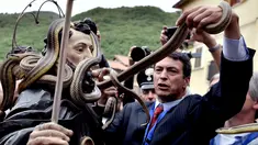 Seorang pria mengambil kembali ular mereka dari patung Saint Domenico setelah prosesi tahunan di Cocullo di Italia (1/5). Setiap tahun di bulan Mei, sejumlah ular ditempatkan di patung St. Domenico dalam prosesi di sekitar kota. (AFP/Tiziana Fabi)