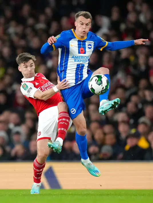 Pemain Arsenal Kieran Tierney (kiri) berebut bola dengan pemain Brighton and Hove Albion Solly March pada pertandingan sepak bola putaran ketiga Piala Liga Inggris atau Carabao Cup di Emirates Stadium, London, Inggris, 9 November 2022. Arsenal tersingkir dari Carabao Cup usai kalah dari Brighton and Hove Albion dengan skor 1-3. (AP Photo/Kirsty Wigglesworth)