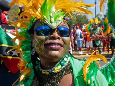Seorang peserta mengenakan kostum saat berpartisipasi dalam Parade West Indian Day di distrik Brooklyn, New York, Senin (3/9). Komunitas Karibia di New York telah mengadakan perayaan tahunan Karnaval sejak tahun 1920. (AP Photo/Craig Ruttle)