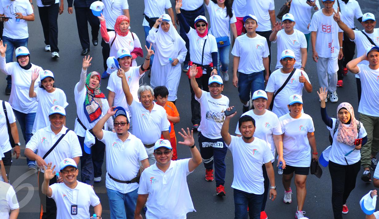 Peserta Fun Walk memperingati ke-70 Hari Bakti Postel terlihat semangat berjalan menuju Bundaran HI, Jakarta, Minggu (8/11/2015). Acara ini digelar Kemkominfo untuk mengenang jasa para pahlawan telekomunikasi Indonesia. (Liputan6.com/Faisal R Syam) 