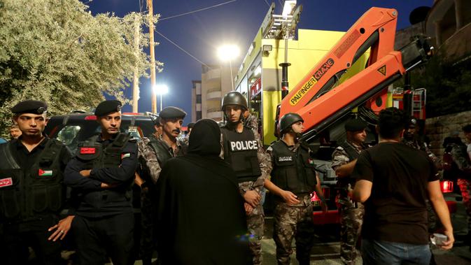 Polisi Yordania mengepung daerah di mana Pertahanan Sipil Yordania melakukan operasi pencarian terhadap penghuni sebuah bangunan tempat tinggal berlantai empat yang runtuh, di Amman, Yordania, Selasa (13/9/2022). Direktorat Keamanan Publik mengatakan tim penyelamat masih mencari korban selamat. (AP Photo/Raad Adayleh)