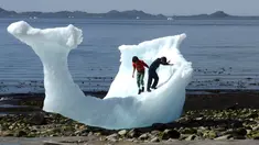Anak-anak bermain di bongkahan es berukuran raksasa di Nuuk, Greenland, 5 Juni 2016. Bongkahan es tersebut berasal dari gunung es yang mancair akibat cuaca panas terus-menerus di Greenland. (REUTERS / Alister Doyle)