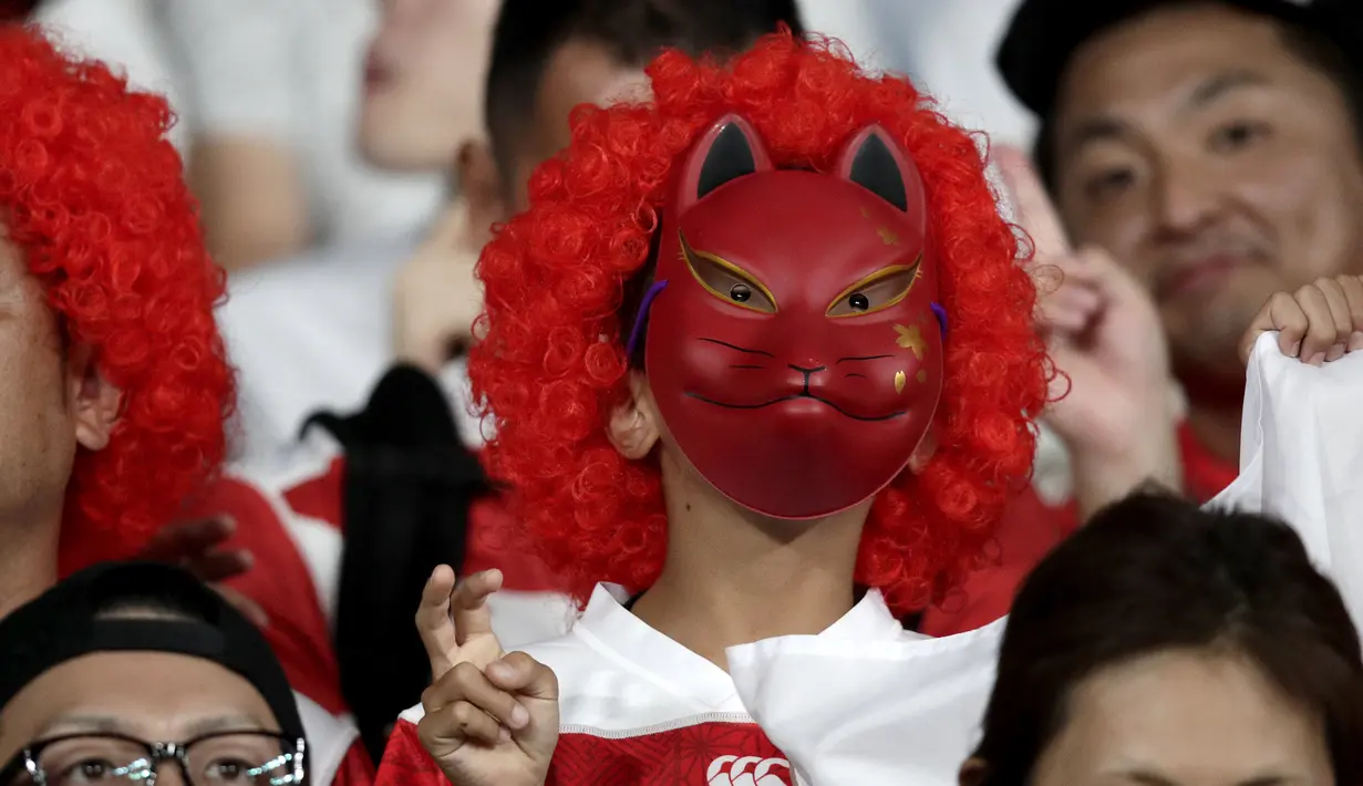 Fans mengunakan topeng kucing menunggu pertandingan melawan Rusia pada pembukaan Rugby World Cup Pool A  di Stadion Tokyo (20/9/201). Rugby World Cup diselenggarakan dari 20 September hingga 2 November 2019. (AP Photo/Jae Hong)
