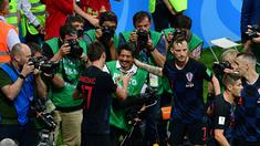 Mario Mandzukic (kiri) dan Ivan Rakitic menyapa fotografer AFP, Yuri Cortez (tengah) usai merayakan gol pada semifinal Piala Dunia 2018 di Luzhniki Stadium, Moskow, (11/7/2018). Yuri jatuh saat perayaan gol skuat Vatreni. (AFP/Mladen Antonov)