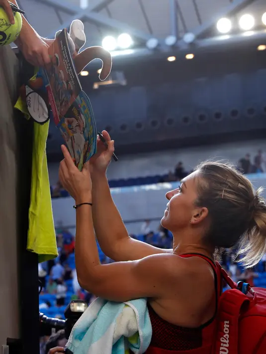 Petenis asal Rumania, Simona Halep memberikan tanda tangan kepada fans usai bertanding melawan petenis Jepang Naomi Osaka di putaran keempat di kejuaraan tenis Australia Terbuka di Melbourne, (22/1). Halep menang 6-3, 6-2. (AP Photo / Ng Han Guan)