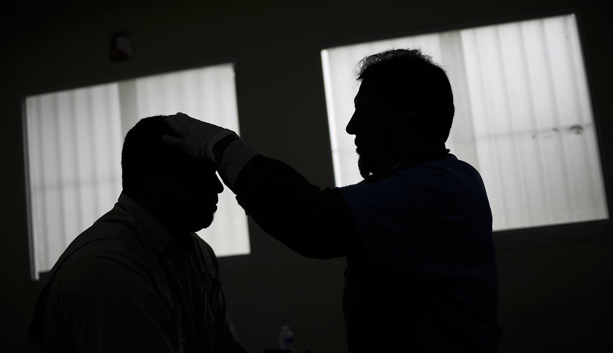 Seorang dokter melakukan terapi akupunktur pada pasien terpapar virus Corona COVID-19 yang baru pulih di pusat kesehatan yang dikelola pemerintah di lingkungan Coche di Caracas, Venezuela pada 25 Februari 2021. (AP Photo / Matias Delacroix)