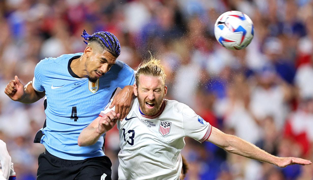 Pemain Uruguay, Ronald Araujo (kiri) berduel udara dengan pemain Amerika Serikat, Tim Ream pada laga Grup C Copa America 2024 di Arrowhead Stadium, Kansas City, Missouri, Selasa (07/02/2024) WIB. (AFP/Michael Reaves)