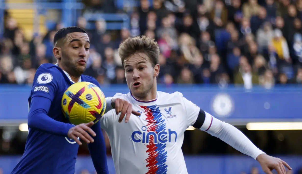 Pemain Chelsea, Hakim Ziyech (kiri) berebut bola dengan dengan pemain Crystal Palace, Joachim Andersen pada pertandingan lanjutan Liga Inggris di Stadion Stamford Bridge di London, Minggu (15/1/2023). Hasil tersebut menjadi kemenangan pertama Chelsea setelah kalah beruntun dalam tiga laga terakhir. (AP Photo/David Cliff)