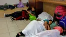 Sementara yang lain tidur di lorong atau kursi bandara menunggu informasi. (Juan Carlos CISNEROS / AFP)