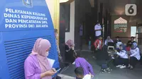 Sejumlah warga menunggu proses administrasi perubahan nama jalan pada KTP elektronik di Halaman Masjid Al Hikmah Hidayah, Cipayung, Jakarta Timur, Rabu (29/6/2022). Pemprov DKI Jakarta menggelar pelayanan jemput bola di enam wilayah terkait perubahan data administrasi kependudukan imbas pergantian 22 nama jalan menggunakan nama tokoh Betawi. (Liputan6.com/Herman Zakharia)