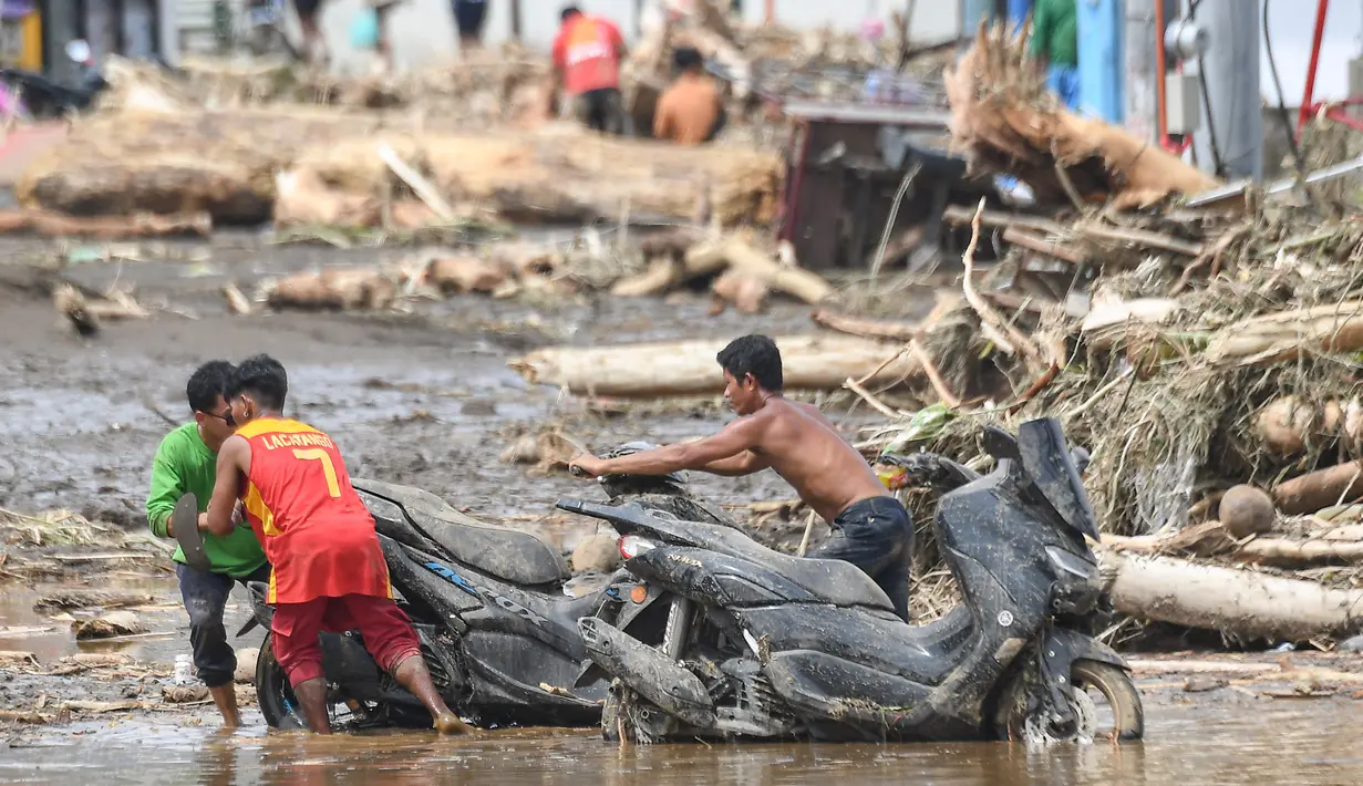 Di daerah Bicol, sebelah tenggara Manila, Badai Trami menyebabkan banjir yang merendam jalanan, lingkungan, mal, dan areal persawahan, dan memutus aliran listrik. (Ted ALJIBE/AFP)