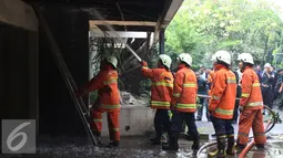 Sejumlah petugas saat menyemprotkan air ke atap rumah yang terbakar di Kebayoran Baru, Jakarta Selatan, Rabu (26/08/15). Penyebab kebakaran belum diketahui tidak ada korban jiwa dalam kebakaran tersebut. (Liputan6.com/Gempur M Surya)