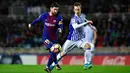 Pemain Barcelona, Lucas Digne berebut bola dengan kiper Real Sociedad, David Zuturuza pada laga pekan ke-19 La Liga di Stadion Anoeta, Minggu (14/1). Kemenangan berhasil diraih Barcelona 4-2 saat menghadapi Real Sociedad. (AP/Alvaro Barrientos)
