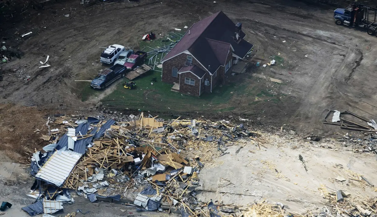 Rumah dan mobil yang rusak terlihat di Waverly, Tennessee, Rabu (25/8/2021). Hujan deras selama akhir pekan menyebabkan banjir di Tennessee Tengah dan telah mengakibatkan puluhan orang tewas karena rumah dan jalan pedesaan hanyut. (AP Photo/Mark Humphrey)