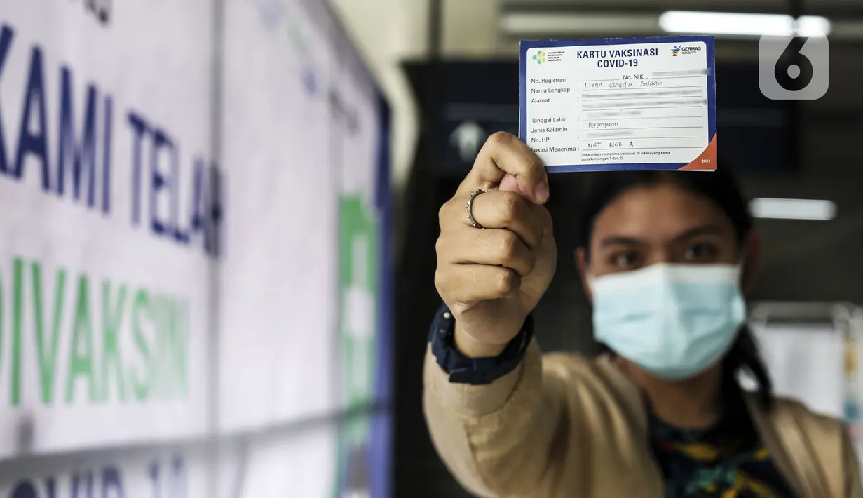 Warga menujukkan Kartu Vaksinasi COVID-19 saat mengikuti vaksinasi gratis di Stasiun MRT, Jakarta, Jumat (23/7/2021). Penyuntikan vaksin COVID-19 dosis pertama tersebut menargetkan 1.800 peserta. (Liputan6.com/Johan Tallo)