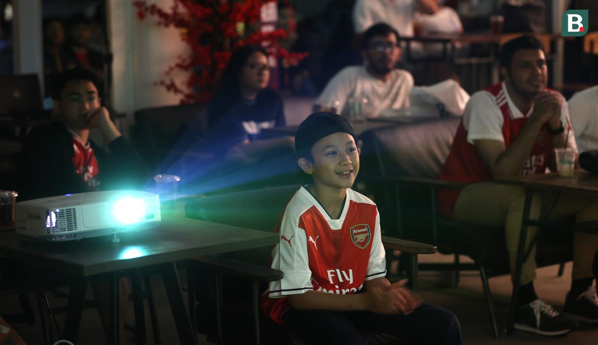 Seorang fans cilik Arsenal tampak tersenyum semringah melihat tim kebanggaanya memimpin lima gol saat melawan Burnley di Liga Inggris. (Bola.com/M Iqbal Ichsan)