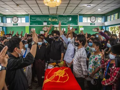 Orang-orang memberi hormat tiga jari selama pemakaman Khant Ngar Hein di Yangon, Myanmar, Selasa (16/3/2021).  Khant Ngar Hein, seorang mahasiswa kedokteran berusia 18 tahun ditembak di dadanya pada hari Minggu, 14 Maret di Tamwe, Yangon oleh pasukan keamanan selama protes anti-militer. (AP Photo)