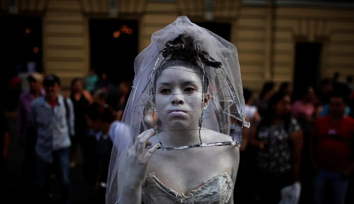 Seorang kontestan beraksi saat mengikuti kontes patung di pusat kota San Salvador , El Salvador, (18/6). Kontes ini menjadi tontonan warga El Savador yang sedang melintas. (REUTERS / Jose Cabezas)