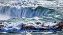 Es dan air mengalir di tepi Horseshoe Falls dari Air Terjun Niagara di Ontario, Kamis (31/1). Saat AS dilanda suhu yang lebih dingin dari Antartika, temperatur di Kanada juga menurun menjadi minus 18 derajat Celcius (Tara Walton/The Canadian Press via AP)
