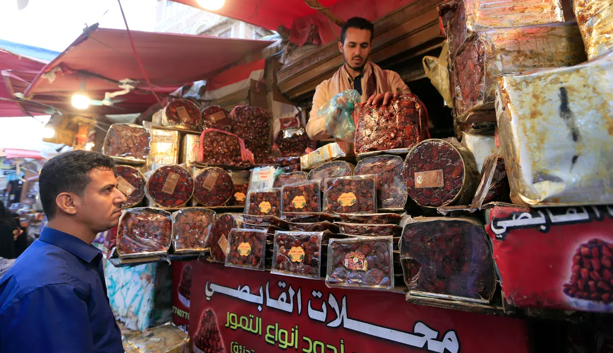 Seorang pria membeli kurma selama bulan suci Ramadan di sebuah pasar di ibukota Sanaa, Yaman (22/5). (AFP Photo/Mohammed Huwais)