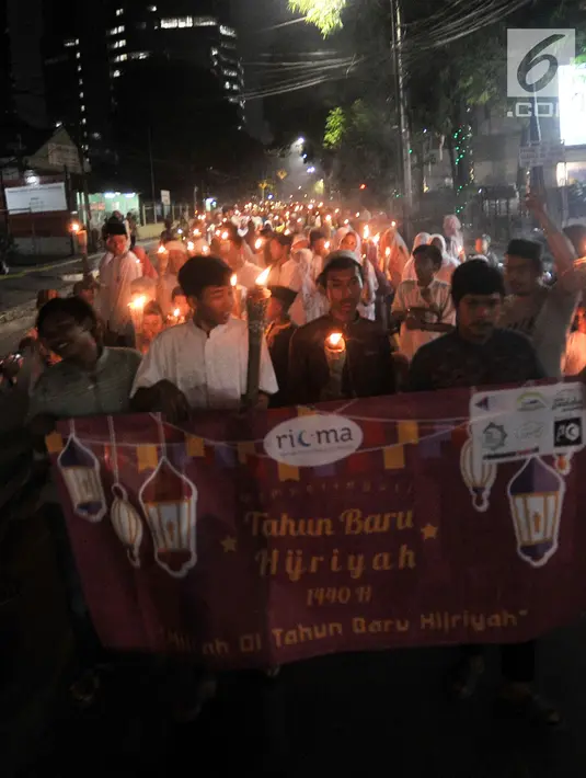 Warga membawa obor saat pawai Tahun Baru Islam 1440 H di kawasan Menteng, Jakarta, Senin (10/9). Pawai obor yang diiringi musik bernuansa Islam merupakan tradisi umat muslim di Indonesia menyambut Tahun Baru 1 Muharram. (Merdeka.com/Iqbal S Nugroho)
