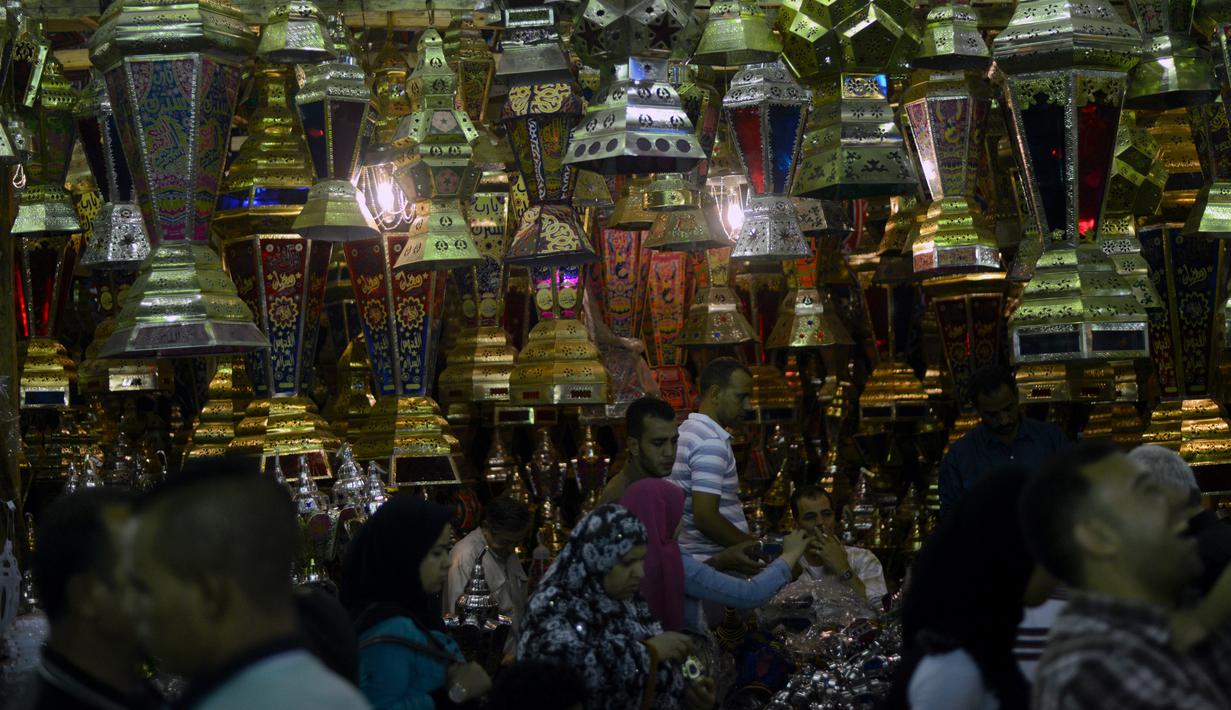 Warga berjalan melewati lampu fanus, lentera tradisional khas yang dijual selama Ramadan, di distrik Saida Zeinab di Ibu Kota Kairo, 29 Mei 2016. Masyarakat Mesir mulai memburu lampu fanus yang merupakan dekorasi khas Ramadan. (MOHAMED EL-Shahed /AFP)