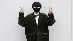 Nagomi Tanahara berusia 20 tahun mengenakan jas hitam berpose di luar Todoroki Arena selama upacara perayaan "Coming-of-Age Day" di Kawasaki, prefektur Kanagawa (11/1/2021). Lebih dari 1 juta anak muda di Jepang berulang tahun yang ke-20 pada 2021.  (AFP/Behrouz Mehri)