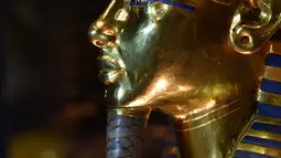 Topeng emas Raja Tutankhamun diperlihatkan di museum Mesir di Kairo, Rabu (16/12). Sebelumnya, tim ahli dari Jerman bekerja selama 2 bulan menghapus kerak lem kering di jenggot dari peninggalan tidak ternilai harganya tersebut. (AFP/MOHAMED EL-SHAHED)