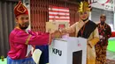 Petugas KPPS memasukkan surat suara seusai mencoblos pada Pilkada Serentak 2018 di TPS XII Kelurahan Sei Mati, Kecamatan Medan Maimun, Rabu (27/6). Baju adat dari berbagai daerah dan suku tampak dikenakan oleh petugas TPS. (Liputan6.com/Reza Perdana)