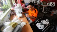 Penyandang disabilitas menyelesaikan pekerjaan menjahit di Wisma Yayasan Cheshire Indonesia di Cilandak, Jakarta Selatan, Senin (3/7/2020). (merdeka.com/Arie Basuki)
