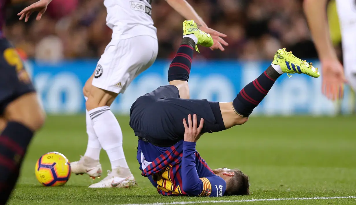 Pemain Barcelona, Lionel Messi terjatuh saat bertanding melawan Valencia dalam lanjutan Liga Spanyol di Camp Nou, Spanyol, Minggu (3/2). Dua gol Messi membuat pertandingan berakhir 2-2. (AP Photo/Manu Fernandez)