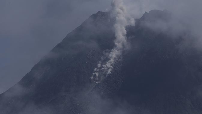 Gunung Merapi memuntahkan material vulkanik dari kawahnya seperti yang terlihat dari Sleman, Yogyakarta (7/1/2021). Teramati asap kawah utama berwarna putih dengan intensitas sedang hingga tebal, tinggi asap sekitar 20-100 meter dari puncak. (AP Photo/Slamet Riyadi)