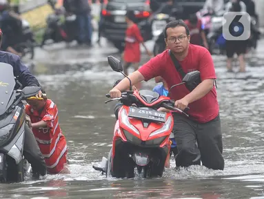 Kendaraan bermotor menerobos banjir di Jalan Daan Mogot Jakarta Barat, Rabu (14/2/2024). (merdeka.com/Arie Basuki)