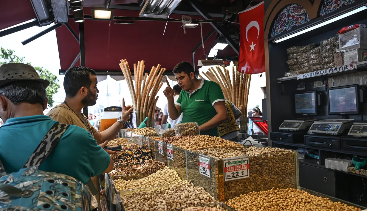 Pedagang melayani pembeli di Spice Bazaar yang bersejarah di distrik Eminonu di Istanbul, Turki (13/7/2019). Tempat tersebut menjadi spesial karena berbagai macam rempah-rempah pedas khas Turki dijual disitu. (AFP Photo/Ozam Kose)