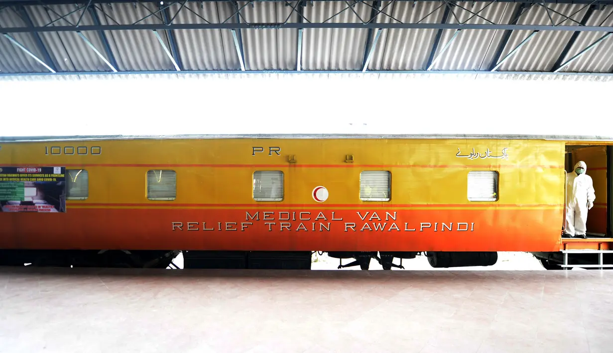 Seorang staf medis yang mengenakan pakaian pelindung berdiri di pintu masuk kompartemen kereta api yang diubah menjadi bangsal karantina untuk virus Corona COVID-19  di stasiun kereta api di Rawalpindi, Provinsi Punjab, Pakistan timur, pada 30 Maret 2020. (Xinhua/Ahmad Kamal)