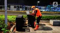 Pasukan oranye mengumpulkan sampah di tengah Pandemi Covid-19, Jakarta, Jumat (8/5/2020). Semenjak diberlakukan Pembatasan Sosial Berskala Besar (PSBB) yang diterapkan Ibu Kota membuat aktivitas warga berkurang dan jalan menjadi lengang. (merdeka.com/Imam Buhori)