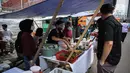 Pedagang melayani pembeli di Pasar Takjil Benhil, Jakarta, Selasa (13/4/2021). Pasar takjil yang ada setiap bulan Ramadhan tersebut dipadati warga untuk membeli makanan berbuka puasa. (Liputan6.com/Faizal Fanani)