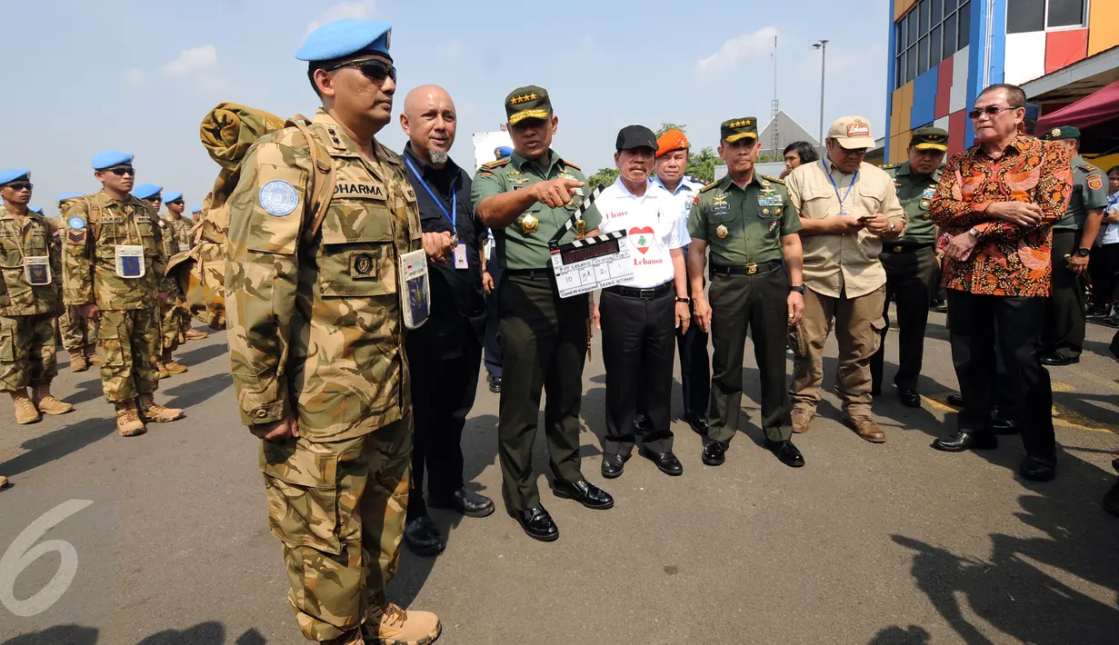 Panglima TNI Jenderal TNI Gatot Nurmantyo (tengah) memegang papan scene saat meninjau syuting perdana film ”Garuda 23” di Bandara Halim Perdanakusuma, Jakarta, Jumat (29/7). Film ini bertema misi perdamaian pasukan TNI. (Liputan6.com/Helmi Fithriansyah)