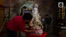 Warga membersihkan patung di Wihara Amurva Bhumi, Jakarta, Jumat (2/2/2024). (Liputan6.com/Herman Zakharia)