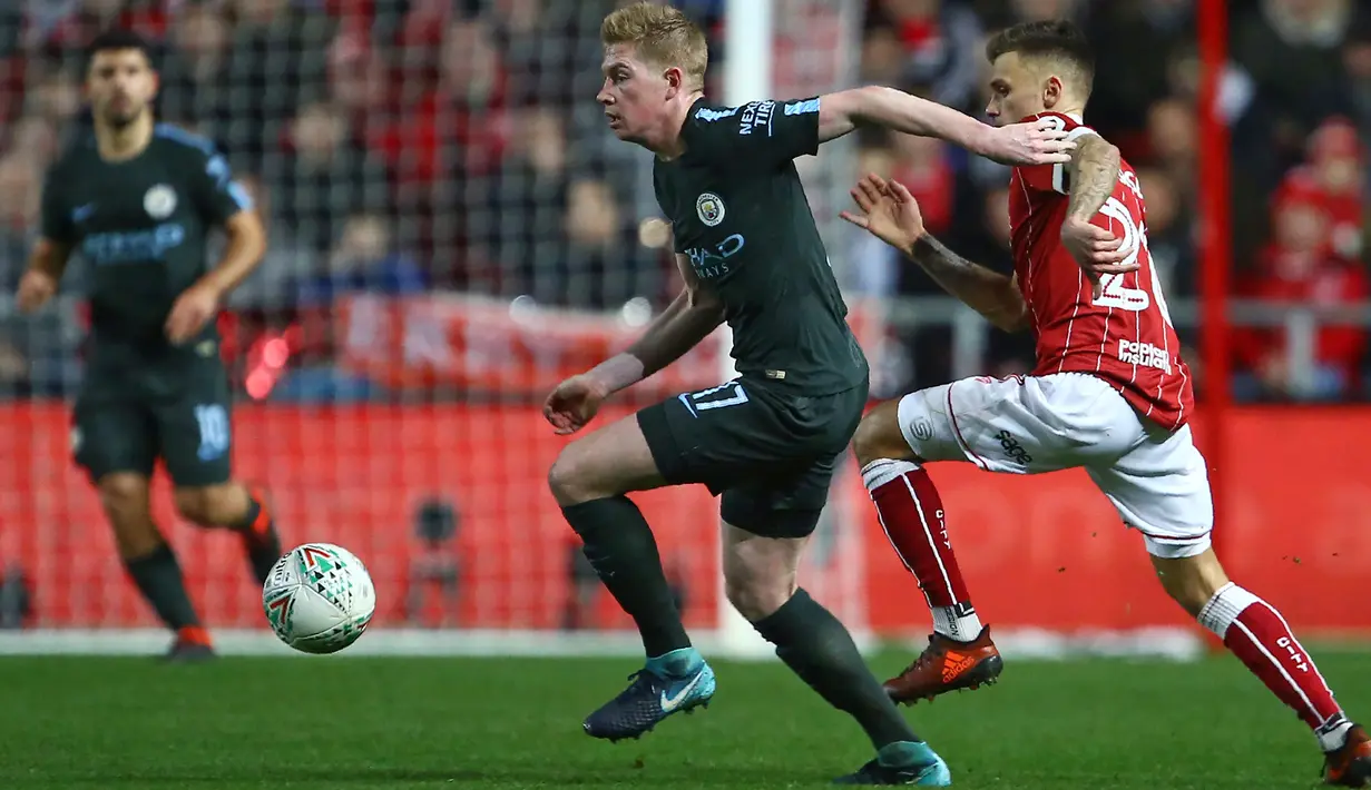 Aksi pemain Manchester City, Kevin De Bruyne menggiring bola melewati adangan pemain Bristol City pada semifinal Piala Liga Inggris di Ashton Gate stadium, Bristol,(23/1/2018). Manchester City menang 3-2. (AFP/Geoff Caddick)