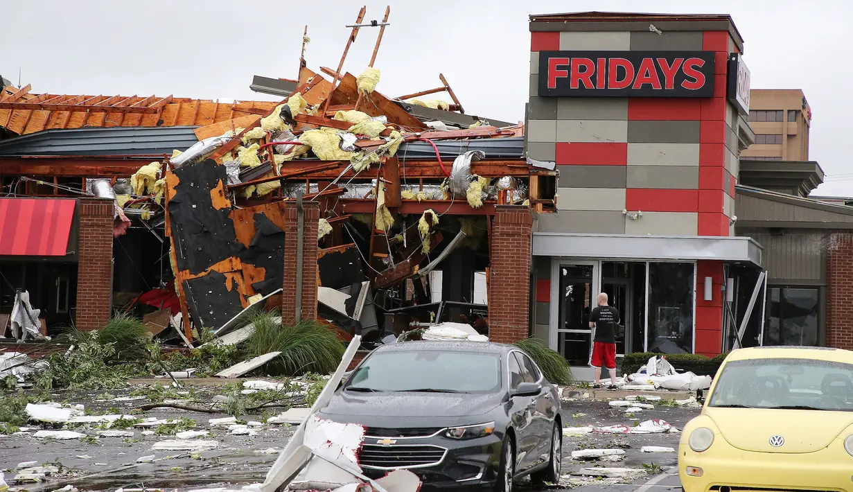 Seorang pria berdiri mengamati restoran yang ambruk akibat tornado di Tusla, Oklahoma, Minggu (6/8). Badai menyebabkan pemadaman listrik lebih dari 11.000 bangunan dan kerusakan di setiap sudut kota Tusla. (Tulsa World via AP/Tom Gilbert)
