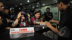 Guru kembar dari Sekolah Darurat Kartini saat menulis daftar hadir di Lobi KPK, Jakarta, Senin (26/1/2015). Kunjungan mereka sebagai bentuk dukungan kepada KPK.(Liputan6.com/Herman Zakharia) 