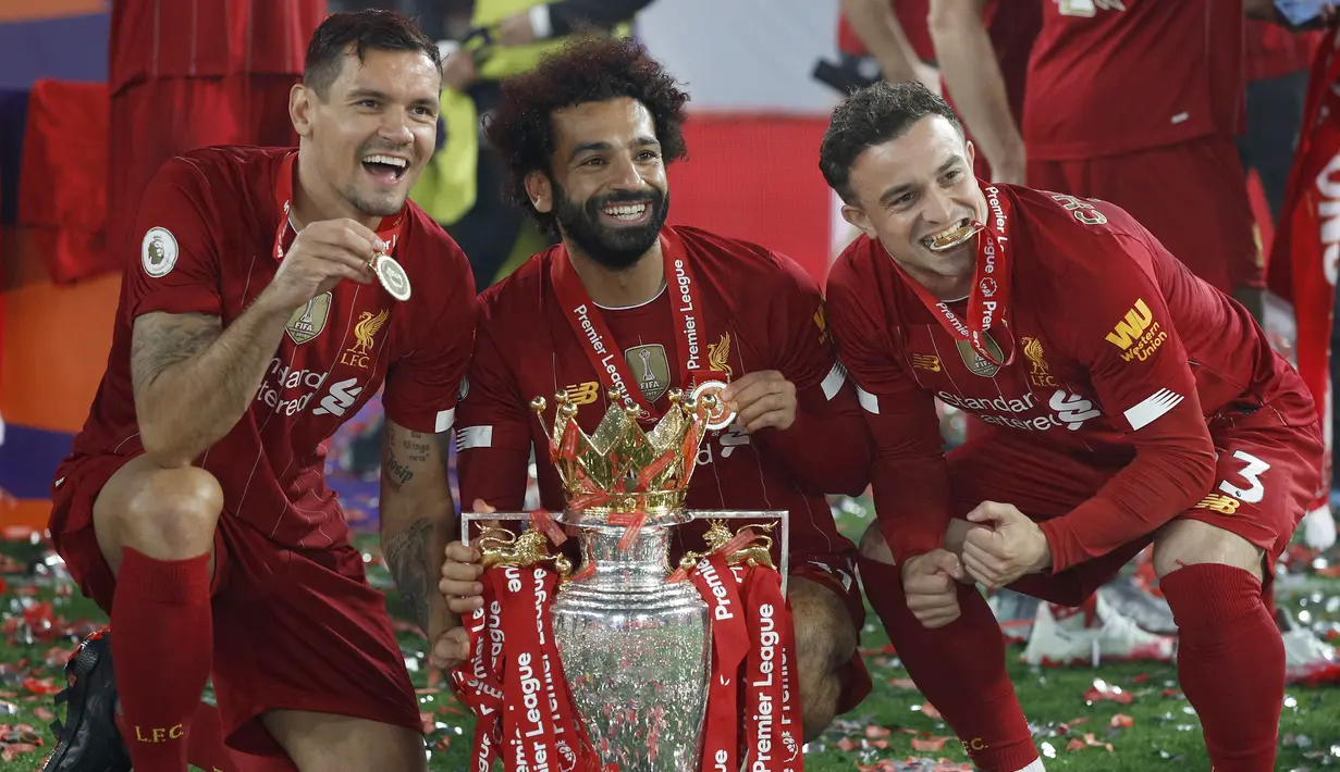 Pemain Liverpool, Mohamed Salah, Xherdan Shaqiri dan Dejan Lovren, saat merayakan trofi juara Premier league 2019-2020 di Stadion Anfield, Kamis (23/7/2020) dini hari WIB. Prosesi angkat trofi juara ini dilakukan usai pertandingan Liverpool melawan Chelsea. (AFP/Phil Noble/pool)
