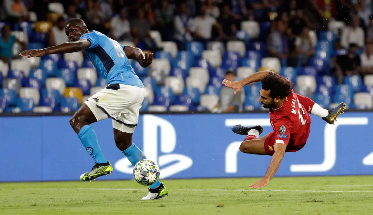 Penggawa Liverpool, Mohamed Salah mencoba mencetak gol saat pemain Napoli, Kalidou Koulibaly berusaha menahan tendangan pada matchday pertama Grup E Liga Champions di Stadion San Paolo, Selasa (17/9/2019). Napoli menundukkan Liverpool 2-0. (AP/Gregorio Borgia)