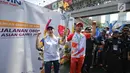 Aktor Reza Rahardian membawa obor secara estafet dan menyerahkan kepada Direktur konsumer Bank BRI Handayani saat prosesi Torch Relay Asian Games 2018 di Jakarta, Sabtu (18/8). Kirab Obor Asian Games telah mencapai puncaknya. (Liputan6.com/Faizal Fanani)